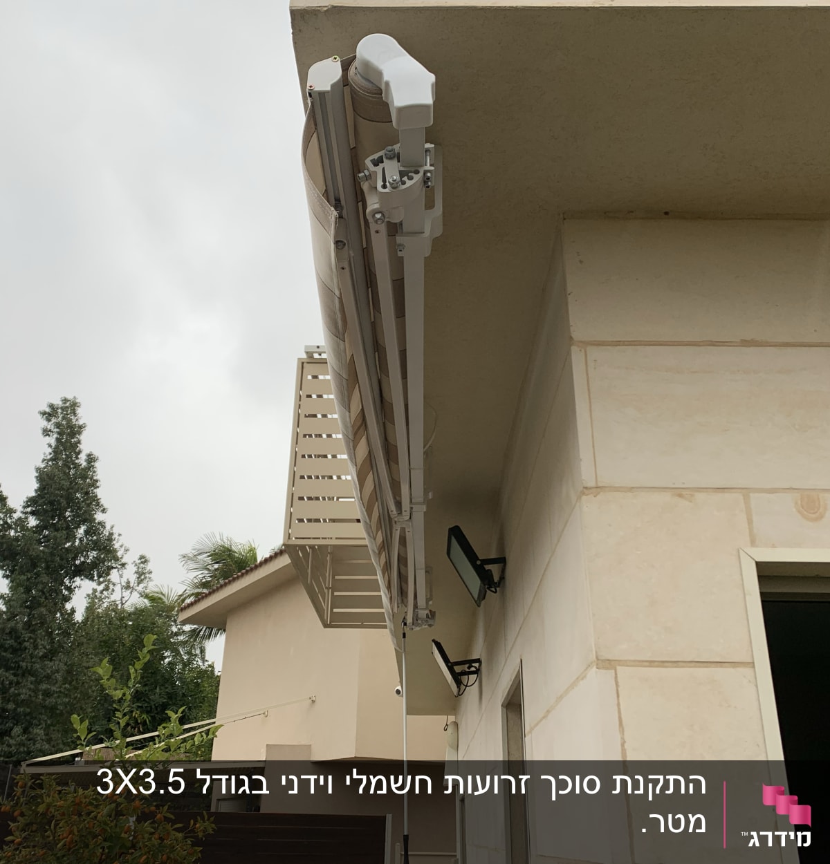 סוכך מתקפל מותקן על קיר חיצוני של בית